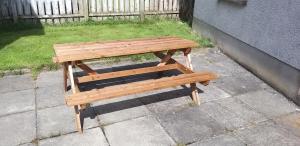 a wooden bench sitting on top of a sidewalk at Laurelbrook Town House in Magherafelt