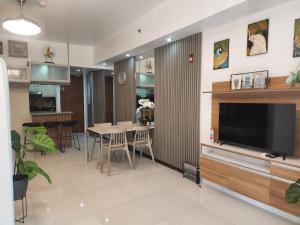 ein Wohnzimmer mit Fernseher und ein Esszimmer in der Unterkunft Pico De Loro Myna A Batangas in Nasugbu