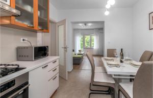 a kitchen and dining room with a table and chairs at Awesome Apartment In Tribalj With Kitchen in Tribalj