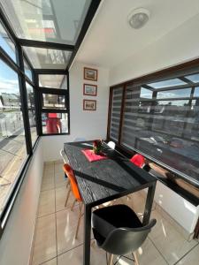 a dining room with a table and chairs and windows at Safi Luxury Self-Catering Suite 8 in East London