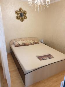 ein Bett in einem Schlafzimmer mit einer Uhr an der Wand in der Unterkunft EL Mar Sole in Eforie Sud