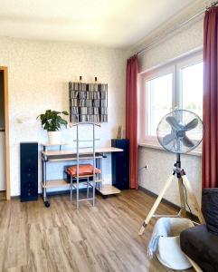 a living room with a fan and a desk at Alraftsblick in Waldeck