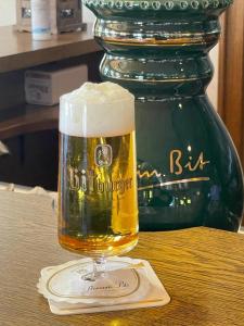 um copo de cerveja sentado em cima de uma mesa em Gasthaus Hubertus em Reuth