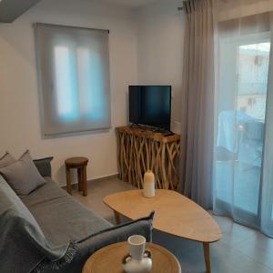 a living room with a couch and a tv and a table at Brand new flat near de bosset bridge, Argostoli in Argostoli