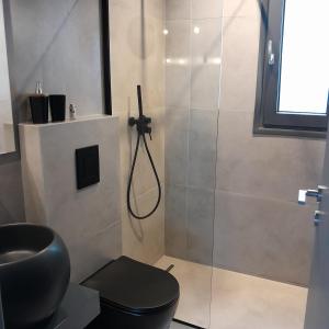 a bathroom with a shower and a black toilet at Brand new flat near de bosset bridge, Argostoli in Argostoli