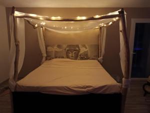 a bed with a head with lights on it at séjour bien-être balnéothérapie en vallée heureuse à Sorede in Sorède