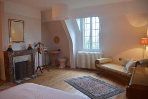 ein Wohnzimmer mit einem Sofa und einem Kamin in der Unterkunft Manoir Normand au cœur d’un Domaine Equestre in Saint-Samson