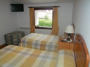 a room with two beds and a window at Pension Gades in Cabezón de la Sal