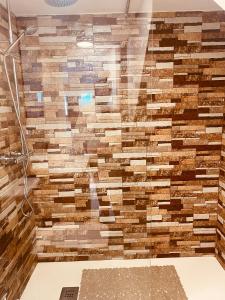 a shower with a wall made of wooden blocks at SUITE COCO in Maspalomas