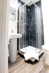 a bathroom with a shower and a sink and a toilet at The Britannia Inn in Elterwater