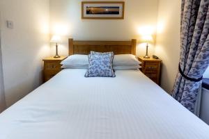 a hotel room with a bed and two nightstands at The Britannia Inn in Elterwater