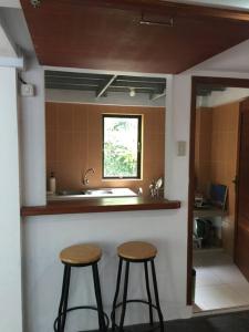 a kitchen with two bar stools and a sink at Banda Aceh Batoh Homestay - private - fits up to 10 persons in Banda Aceh