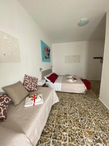 una camera d'albergo con due letti con regali di Rossocorallo Rooms ad Alghero