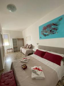 um quarto com 2 camas e toalhas vermelhas e brancas em Rossocorallo Rooms em Alghero