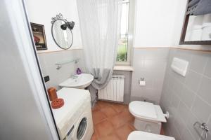 een badkamer met een wit toilet en een wastafel bij B&B La Pellizzera in Vigevano