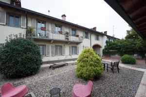 einen Innenhof mit rosa Stühlen und ein Gebäude in der Unterkunft B&B La Pellizzera in Vigevano
