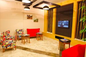 una sala de espera con sillas rojas y TV de pantalla plana. en Fayton Hotel, en Akhisar