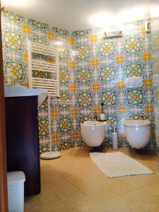 a bathroom with two sinks and a mosaic wall at B&B Martina in Taormina