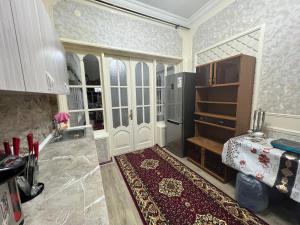 cocina con nevera, mesa y alfombra en Bruce hostel en Dushanbe