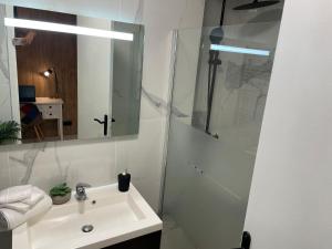a white bathroom with a sink and a shower at Centre de Juan les pins 100m plages Easy Check-in in Juan-les-Pins