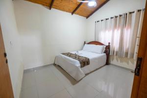 a white bedroom with a bed and a window at LUAR DO MIRANTE ,casa com AR p temporada piscina aquecida hidro dentro da cidade in Pirenópolis +33 photos