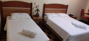 - deux lits assis l'un à côté de l'autre dans une pièce dans l'établissement Itajubá Hotel, à Rio de Janeiro