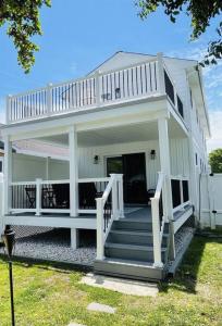a large white house with stairs and a porch at Beautifully Renovated Home with Water Views in Villas