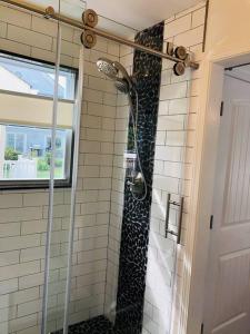 a shower in a bathroom with black and white tiles at Beautifully Renovated Home with Water Views in Villas