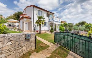 uma casa com um portão e uma parede de pedra em Beautiful Apartment In Barbariga With Kitchen em Barbariga