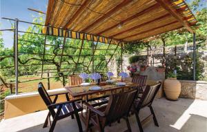 una mesa de madera y sillas en un patio en Beautiful Home In Lovran With House Sea View, en Lovran