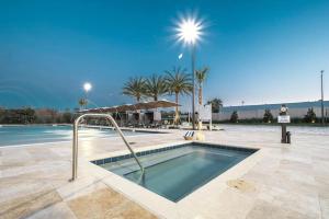 een zwembad in een resort met palmbomen bij Beautiful townhome Magic Village 1,5 mile to Dis in Orlando