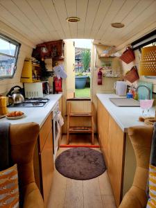 a kitchen in a caravan with a counter and a sink at NEW 2022! Fixed stay characterful narrowboat at the Kelpies, Marigold Sunset in Falkirk