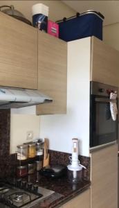 a kitchen with a stove and a counter top at Bel appartement pied sur mer vue imprenable sur piscine et jardins in Sidi Rahal