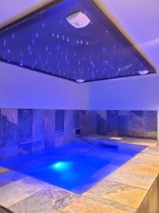 einen Pool in einem Haus mit blauer Decke in der Unterkunft Villa gorille - 240m2- 6chb - SPA-Sauna-Babyfoot-Arcade in Ittenheim