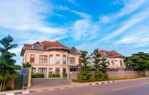a large house with a red roof on a street at Legend Boutique Hotel in Kigali