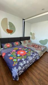 1 dormitorio con 1 cama con edredón de flores en #1.3 Cozy 7Pax Large Beds 2B1R Vivacity Kuching Jazz Suites, en Kuching