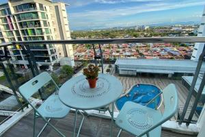- Balcón con mesa y sillas y vistas a la ciudad en #1.3 Cozy 7Pax Large Beds 2B1R Vivacity Kuching Jazz Suites, en Kuching