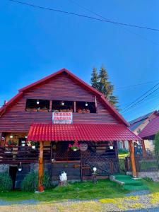 a restaurant with a sign on the front of a building at Cabana Ancuța in Vartop