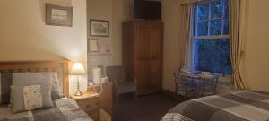 a bedroom with a bed and a table and a window at Bed and Breakfast Ashfield in Pocklington