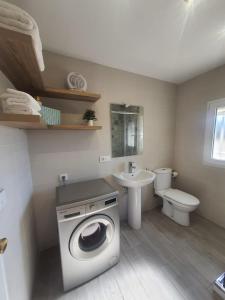 Un baño con lavadora y lavabo. en Apartamento turístico "Mi casina" AT-CC-00782, en Casar de Cáceres 23 fotos más