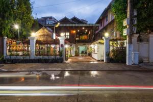 a city street at night with a gate and cars at Happy Heng Heang Guesthouse in Siem Reap