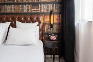 a bedroom with a bed and a side table with a lamp at La Maison Hôtel Mulhouse Centre in Mulhouse