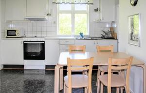 - une cuisine avec une table et des chaises en bois dans l'établissement 1 Bedroom Awesome Home In Vinslv, à Vinslöv