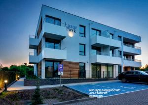 a building with a car parked in front of it at Apartament Burgund Wyspa Sobieszewska in Gdańsk +14 photos