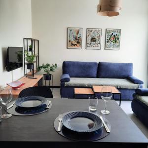 sala de estar con mesa y sofá azul en Apartament Burgund Wyspa Sobieszewska, en Gdansk