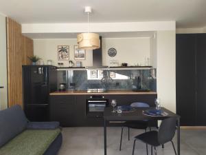 a kitchen with a table and a dining room at Apartament Burgund Wyspa Sobieszewska in Gdańsk
