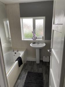a bathroom with a sink and a tub and a window at Sheffield spa view 2 bed house free parking in Sheffield