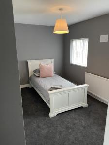 a bedroom with a white bed with a pink pillow at Sheffield spa view 2 bed house free parking in Sheffield