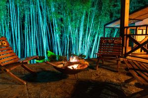 a fire pit in front of a wall of bamboo at Agradable cabaña cafetera con jacuzzi a 12 min del centro de pereira in Pereira