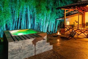 a room with a swimming pool in front of a bamboo wall at Agradable cabaña cafetera con jacuzzi a 12 min del centro de pereira in Pereira